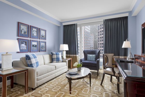 Elegant living room with sofas, lamps, coffee table, and city view.