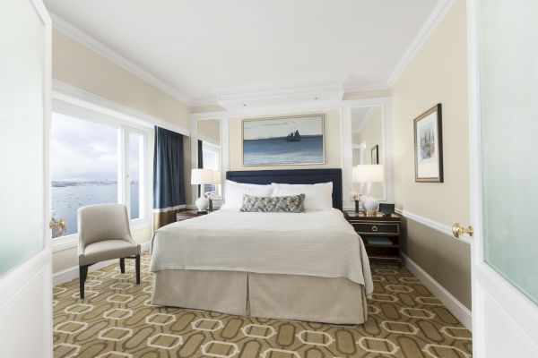 Elegant room with a large bed, artwork, and waterfront view.