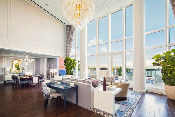 Elegant room with tall windows, plush seating, chandelier, and a dining table.