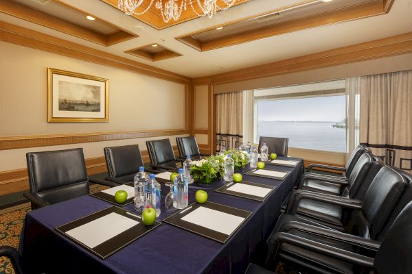 A conference room with a table, chairs, water bottles, notepads,