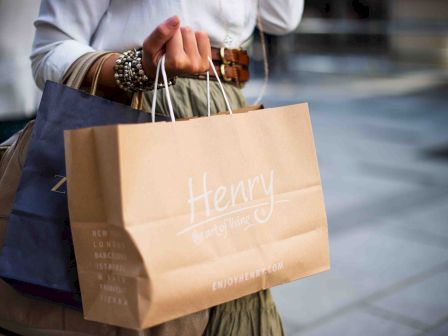 Person carrying a shopping bag labeled 