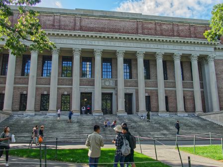 It's a photo of a grand classical building with columns and steps, with people