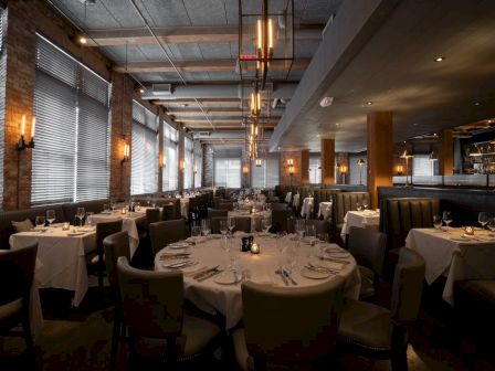 Elegant dining room with set tables, ambient lighting, and a cozy ambiance.