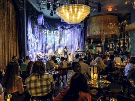 A cozy jazz club with an audience enjoying a live performance under warm lighting.