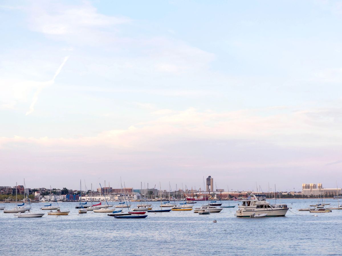 A harbor view with boats, buildings, and a dome structure near the water.