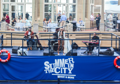 A band is performing on a stage with a sign that reads 