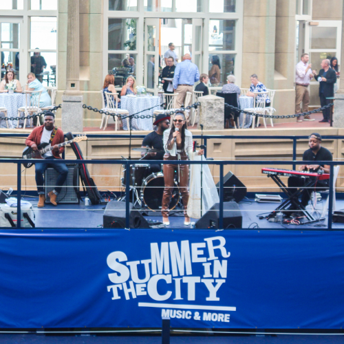 A band is performing on a stage with a sign that reads 