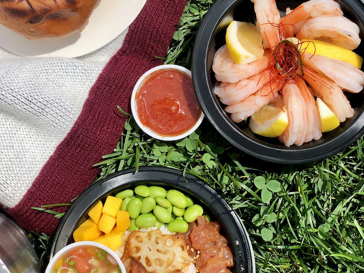 The image shows a picnic scene with various dishes on grass.