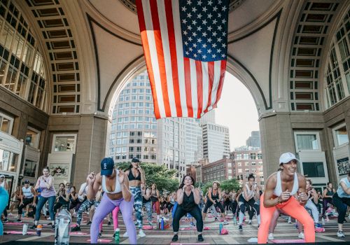 Women working out in a fitness class under an archway