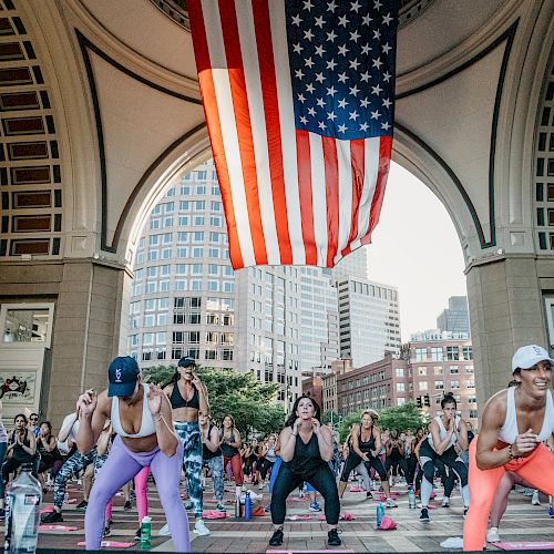 Women working out in a fitness class under an archway