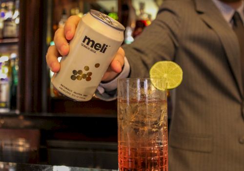 A person in a suit holding a can labeled 